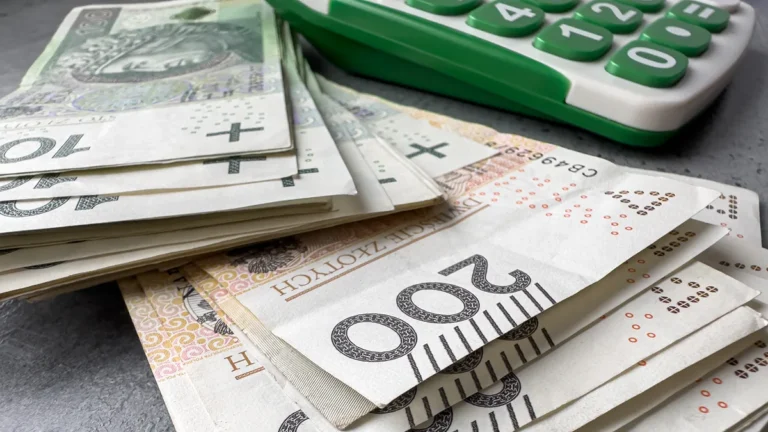 Banknoty 100 i 200 zł obok kalkulatora - wyliczanie raty kredytu gotówkowego na 20, 30 i 50 tys. zł
