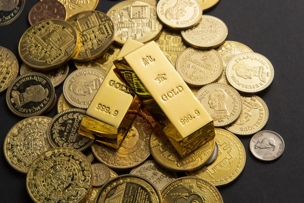Złote sztabki i monety bulionowe rozsypane na stole